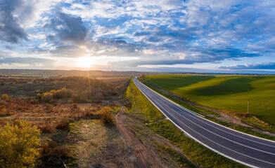 Summer landscape with green field with traffic on the road