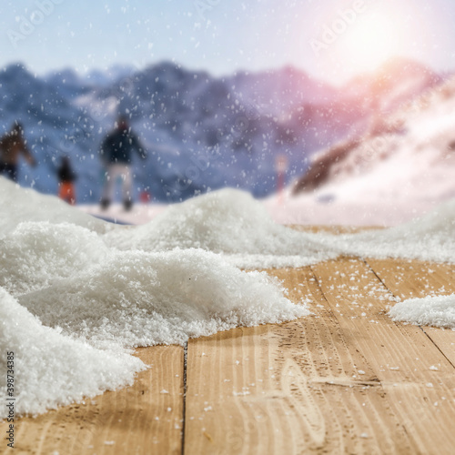 Fototapeta Fresh snow on a wooden table with an alpine view of the mountains