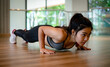 © Near - young Asian woman doing push ups in the gym