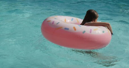 Sticker - beautiful young girl playing with her inflatable donnuts in the swimming pool