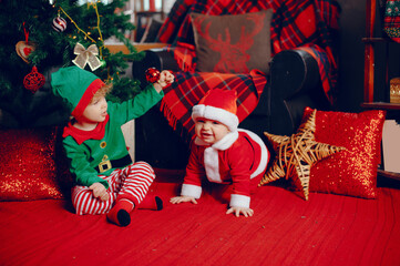 Sticker - Cute little boys in a christmas costumes. Children by the christmas tree