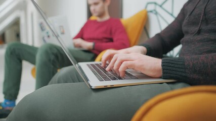 Colleagues programmers are looking on monitor and typing on keyboard in office.Casual businessmen are using laptops to develop new startups.Concept of blockchain development and computer code.