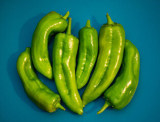 Six Italian Long Sweet Peppers on a blue background