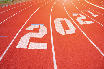 White lines of stadium and texture of running racetrack red rubber racetracks with 2021 Happy New Year text,During Christmas and New Year.