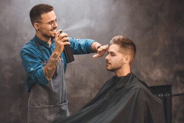 Canvas Print - Professional hairdresser working with client in barbershop