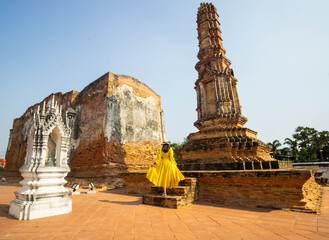 Young Asian woman tourist travel in the old Temple in Thailand.