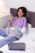 © Анастасия Каргаполов - Happy woman in warm pullover in bed with glass of wine alone by herself resting watching movie comedy smile laugh