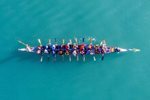 Dragon Boat Team Rowing To The Pace Of An Onboard Drummer, Aerial View.