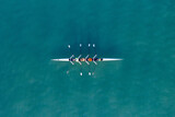 Sport Canoe with a team of four people rowing on tranquil water, Aerial view.