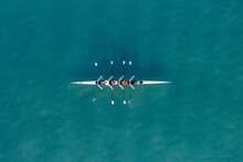 Sport Canoe With A Team Of Four People Rowing On Tranquil Water, Aerial View.