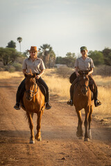 Wall Mural - Blonde and brunette ride along dirt track