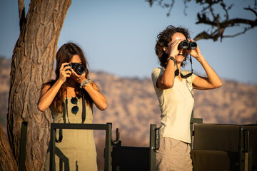 Poster - Brunettes using camera and binoculars in jeep