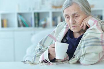 Poster - Portrait of sad old woman with headache drinking tea