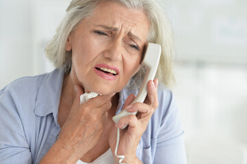 Wall Mural - Portrait of upset senior woman calling doctor