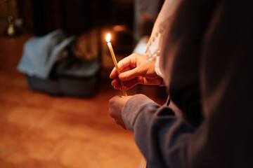 Wall Mural - candle in the hands of a woman in the church during the service. 