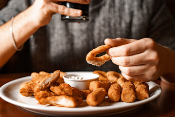 Wall Mural - Hand holds a glass of beer and a plate of snacks