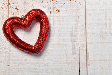 a red heart shape on white wood background with cocoa powder - new year or holiday decoration