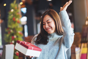 Wall Mural - Happy young woman receiving a gift box