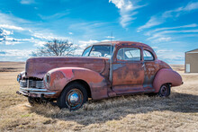 Abandoned Vintage Red Car On The Prairies In Saskatchewan