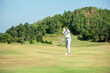 © freebird7977 - Golfer asian man use iron swing and hitting golf ball practice at golf driving range and fairway in sunny morning day on club golf.