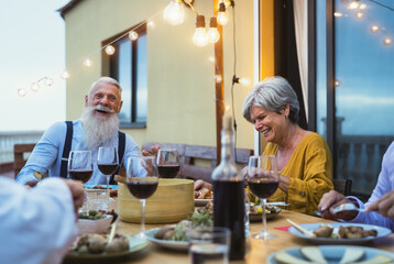 Wall Mural - Happy senior friends having fun dining together on house patio - Elderly lifestyle people and food concept