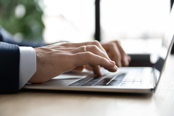 close up businessman using laptop, hands typing on keyboard, employee accountant writing email or fi