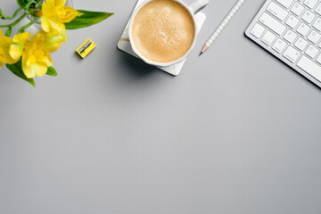 Fototapete - Home office desk table with cup of coffee, keyboard, yellow stationery and flower on grey background. Flat lay, top view, copy space. Minimal style workspace.