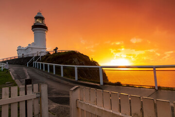 Cape Byron Lighthouse at sunrise under golden skies