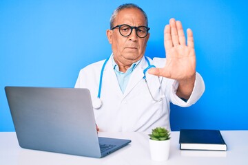 Sticker - Senior handsome man with gray hair wearing doctor uniform working using computer laptop doing stop sing with palm of the hand. warning expression with negative and serious gesture on the face.