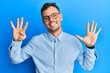 © Krakenimages.com - Young hispanic man wearing casual clothes and glasses showing and pointing up with fingers number nine while smiling confident and happy.