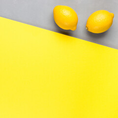 Wall Mural - Colors of year 2021, diagonal with yellow paper and gray concrete texture, fresh lemons on gray background, square