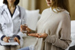 © rogerphoto - Close-up woman-patient holding pills near her doctor, time to take medications, cure for headache or remedy pain killer drugs. Stay at home concept during Coronavirus pandemic and self isolation