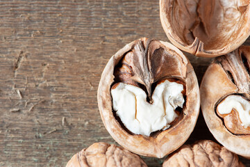 Close-up healthy chopped and unshelled walnuts on a wooden old table. Vegetarian food