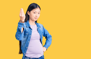 Sticker - Young beautiful chinese woman pregnant expecting baby doing italian gesture with hand and fingers confident expression