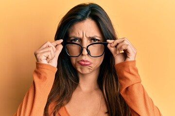 Sticker - Beautiful hispanic woman wearing glasses depressed and worry for distress, crying angry and afraid. sad expression.