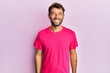 © Krakenimages.com - Handsome man with beard wearing casual pink tshirt over pink background looking positive and happy standing and smiling with a confident smile showing teeth