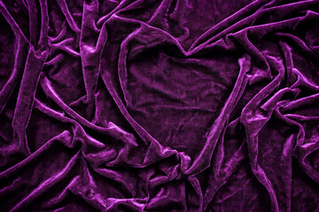 Folds of deep purple velvet material with a heart shape