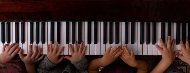 Kids hands playing on the piano, online education