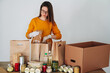 © perfectlab - woman in medical gloves packing food for donation