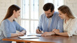 © fizkes - Wide banner view of happy young Caucasian couple sign paperwork close deal with real estate agent. Excited spouse renters put signature on document make agreement with realtor or broker at meeting.
