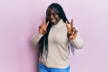 Sticker - Young black woman with braids wearing casual winter sweater smiling looking to the camera showing fingers doing victory sign. number two.