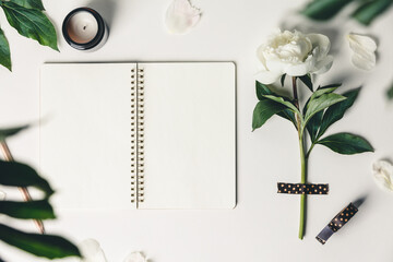 Wall Mural - flat-lay of beautiful peony flower taped on white background and open notebook