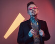 © Fxquadro - Portrait of a positive and stylish male hipster person with tattooed body and fashionable hairstyle in black jacket