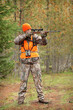© Nathan Allred - adult hunter aiming deer rifle in forest
