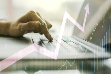 Multi exposure of abstract creative financial chart with upward arrow and hand typing on laptop on background, rise and breakthrough concept