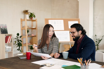 Poster - Young Asian office worker and her happy bearded colleague preparing presentation
