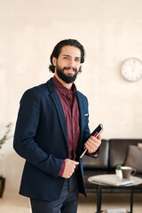 Poster - Young successful businessman in elegant blue suit standing in office environment
