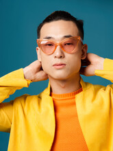 Man In Orange Glasses Blue Background Asian Appearance Yellow Jacket