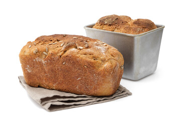 Homemade bread and freshly baked loaf in baking tin on background.