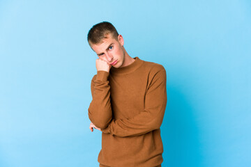 Young caucasian handsome man who feels sad and pensive, looking at copy space.